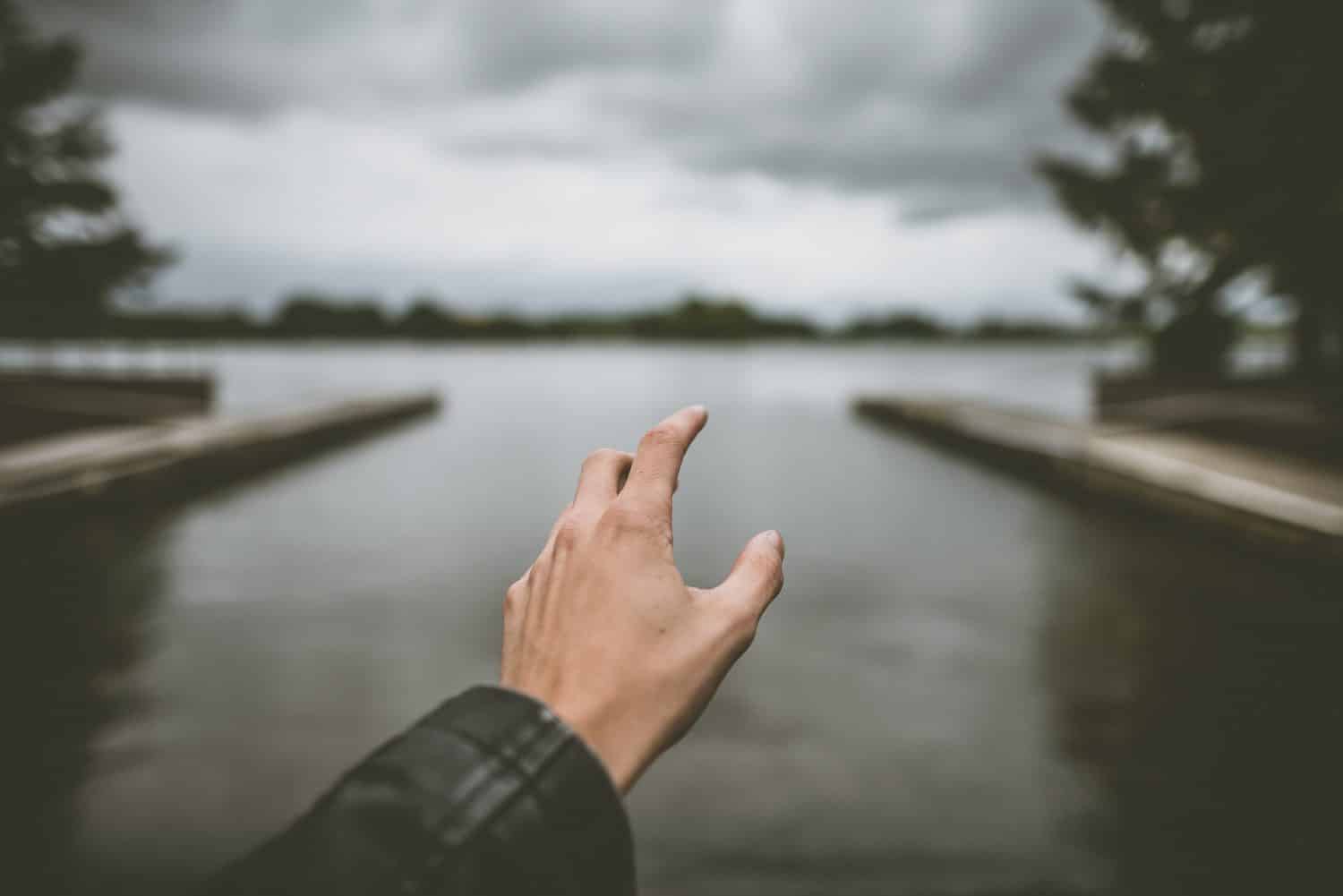 hand and a lake in the background