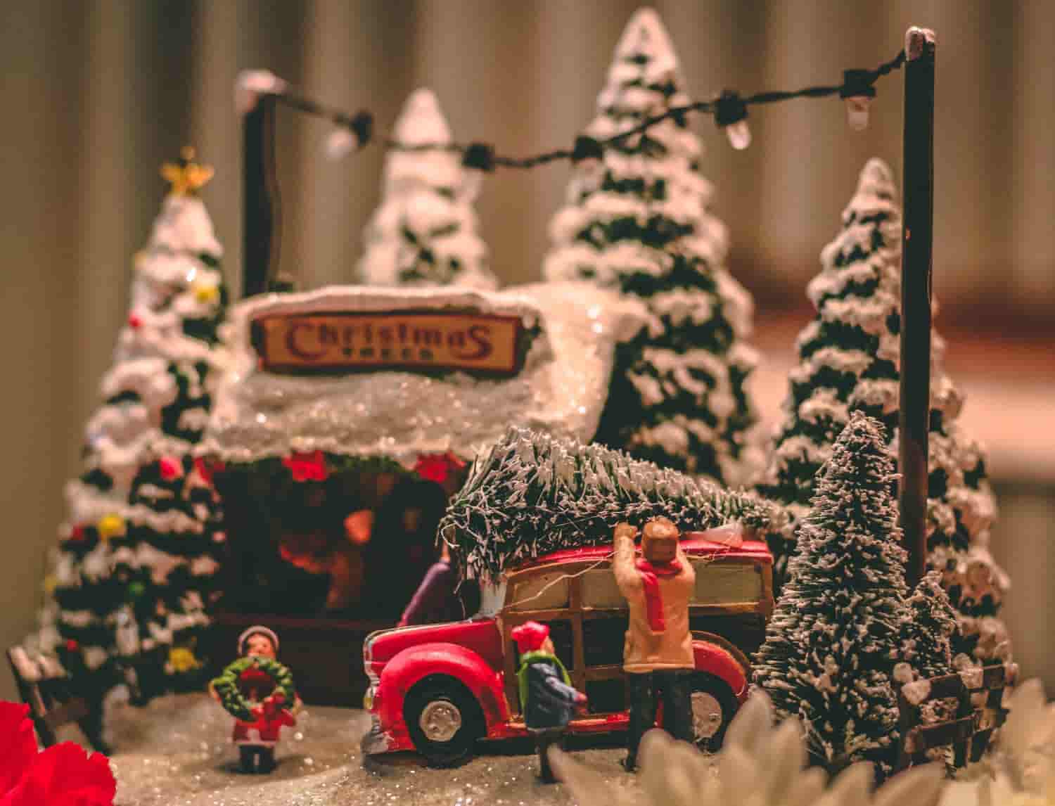 A nice diorama of a car, a dad, two kids and 6 trees with a Christmas Tree store.